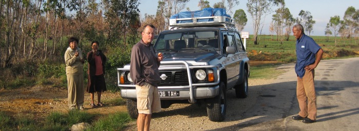 Pause casse croute sur la route de Majunga, trois clients et le chauffeur autour du 4X4